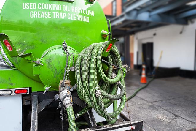 a grease trap being pumped by a sanitation technician in Panorama Village, TX